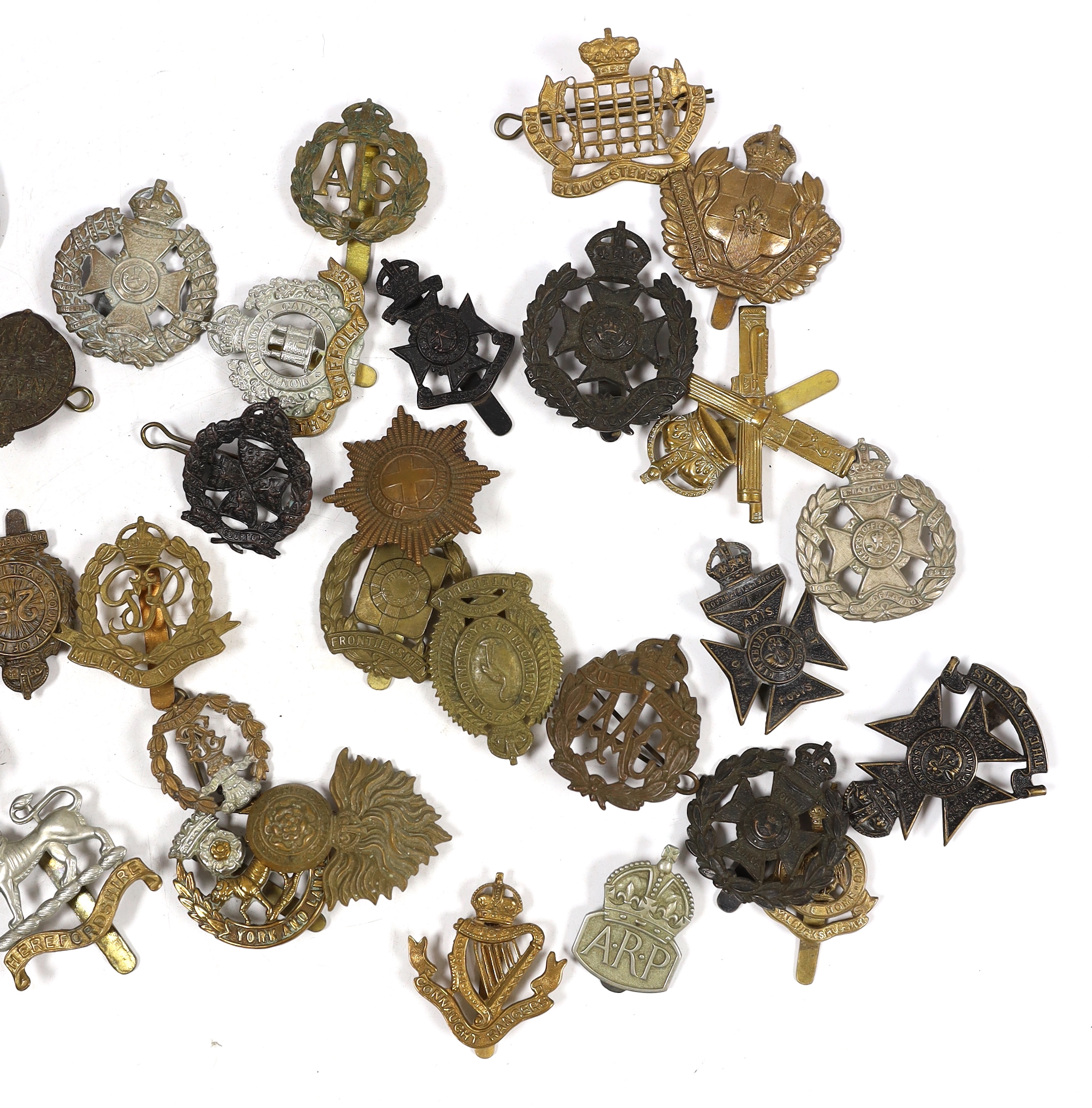 Forty military cap badges including City of London Cyclists, Lincolnshire Yeomanry, Connaught Rangers, The County of London, Royal Gloucestershire Hussars, NAAFI, Military Police, the Rangers, Sussex Yeomanry, Lanarkshir